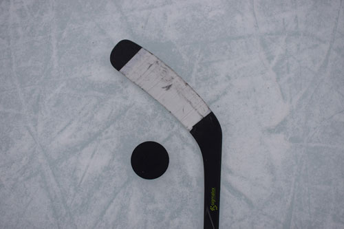 Hockey stick and puck on fresh ice surface